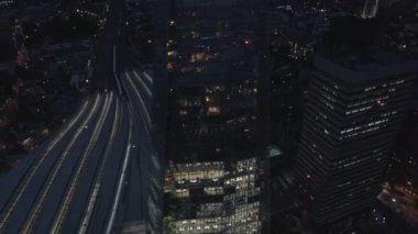 Londra Köprüsü Kulesi 'nin manzarası, Gece Çömleği. İnsansız hava aracı eğiliyor, aydınlık gökdelenin etrafında daireler çiziyor, yukarı doğru eğiliyor ve muhteşem Londra manzarasını gözler önüne seriyor.