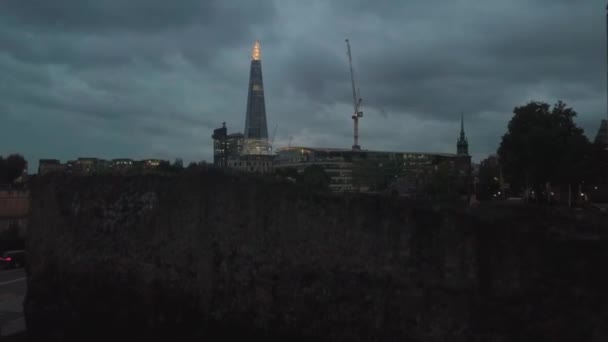 Aerial drone rising above wall reveals The Shard skyscraper in London, UK, evening night — Stock Video