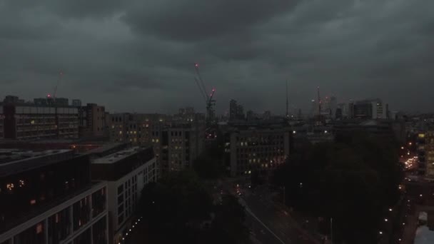 Légi felvétel a londoni pénzügyi negyed városképéről éjszaka. Drone flying back reveal amazing city panorama, Egyesült Királyság, cloudy evening — Stock videók