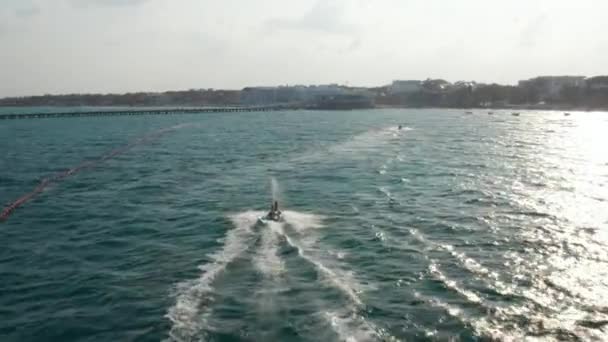 Riding jetski sur la mer des Caraïbes. Un jeune couple fait demi-tour avec le jet ski. Orbite aérienne — Video