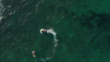 Başka bir su aracının etrafında dönen jet ski. Havadan yukarıdan aşağıya doğru. Karayip Denizi üzerinde dönen insansız hava aracı