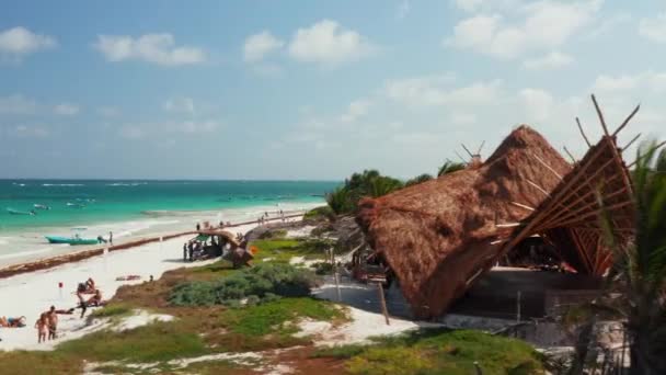 Flygfoto snabb rörelse syn på tält och publik av människor som kopplar av på en tropisk strand på en solig dag och förbereda sig för en tur på båt och simning i Tulum i Mexiko — Stockvideo