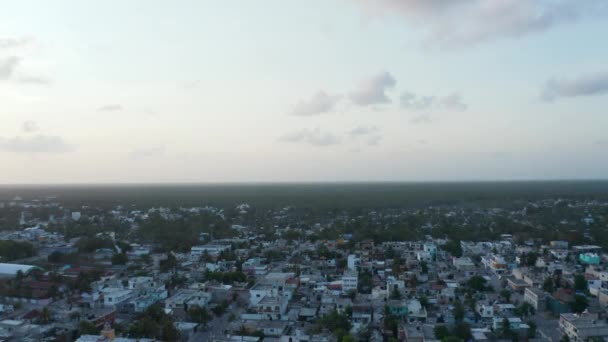 Widok z lotu ptaka i powolny ruch pięknego nowoczesnego miasta Tulum w Meksyku rozprzestrzenił się przez ogromnie rozciągnięty las podczas zachmurzonego nieba o wschodzie słońca — Wideo stockowe