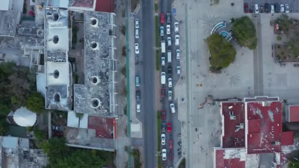 Nad głową widok powolnego ruchu pojazdów poruszających się po ulicach miasta z niektórymi samochodami zatrzymującymi się na czerwonym sygnale podczas wczesnego wschodu słońca w Tulum w Meksyku — Wideo stockowe