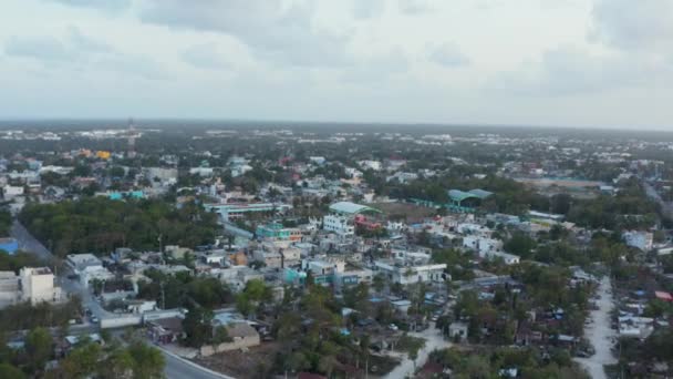 Overhead view of vehicles running on road with buildings and trees on a clear sky during morning in the beautiful city Tulum in Mexico — Stock Video