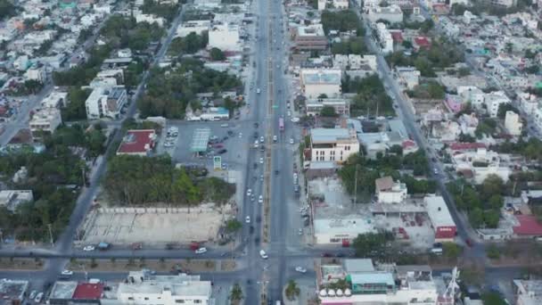 Oprichter slow motion voorwaarts schot van de straten van de stad met voertuigen in beweging omgeven door gebouw en huizen in Tulum in Mexico uitgebreid naar bos met oceaan en heldere hemel — Stockvideo