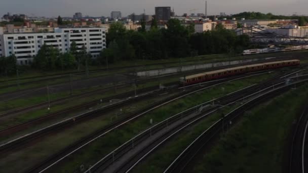 Pan i uchylne nagrania z jazdy pociągu regionalnego na torach kolejowych w godzinach wieczornych holden światło słoneczne. Berlin, Niemcy — Wideo stockowe