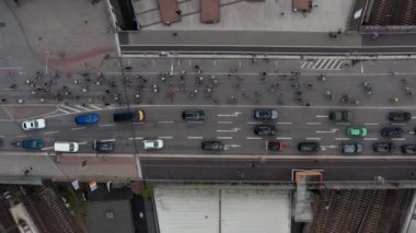 Helikopter kuşları tepeden aşağıya, tren yolu üzerindeki köprüde araba kuyruğundan geçen bisikletçi grubunu görüyor. Özgür ve Hanseyatik Almanya, Hamburg Bisiklet Yürüyüşü