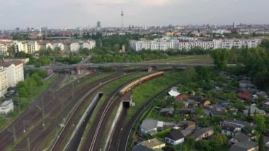 Şehirdeki demiryolu kavşağının üzerinde ilerliyorlar. S bahn treni parkurda duruyor. Berlin, Almanya
