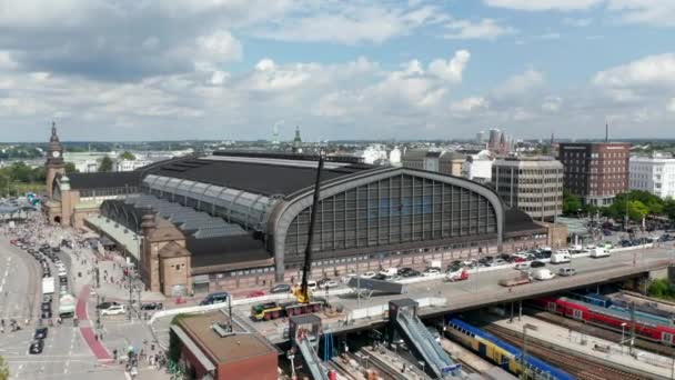 Økende utsikt over historiske bygninger i Hamburg Hauptbahnhof. Lastebilkran som betjenes fra bro over plattformer. Den frie og hanseatiske byen Hamburg, Tyskland – stockvideo
