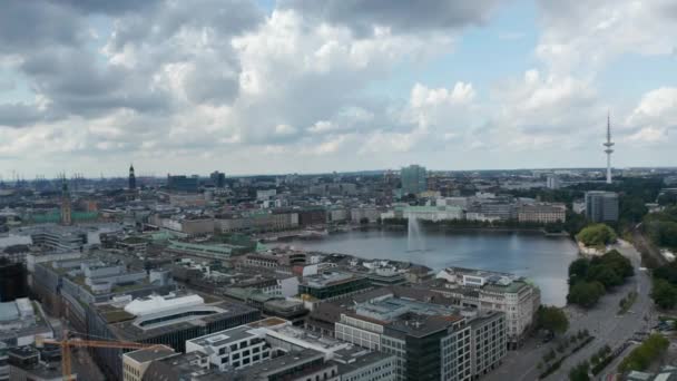 Imágenes aéreas deslizantes de la superficie del agua rodeada de edificios y con fuente en medio. Vuela por el lago Binnenalster. Ciudad Libre y Hanseática de Hamburgo, Alemania — Vídeo de stock