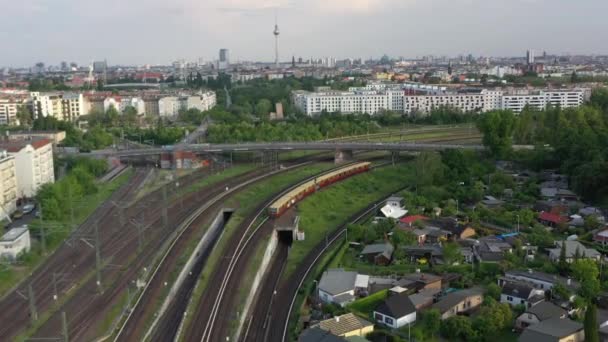 전선은 도시의 철도 교차점 위를 날고 있다. S 반열 차가 선로 위에 서는 것을 추적하고 있습니다. 독일, 베를린 — 비디오