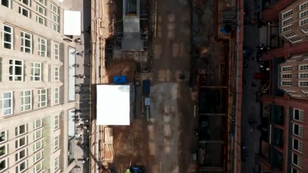 Oiseaux aériens vue aérienne du haut vers le bas des gens marchant le long du chantier de construction dans la rue de la ville. Vue descendante — Video
