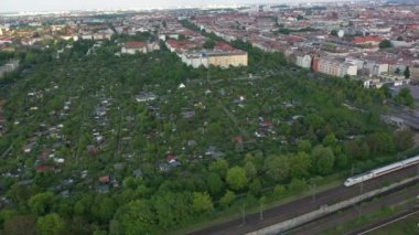 Şehirdeki halk bahçeleri boyunca giden ekspres trenin hava görüntüsü. Sakin ve sakin bir yerleşim bölgesi. Berlin, Almanya