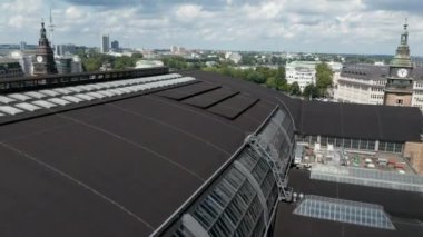 İleri, ana tren istasyonu binasının üzerinden uçun. Köprüde yoğun yol trafiği ve raylarda giden birden fazla tren görülüyor. Özgür ve Hanseyatik Şehir Hamburg, Almanya