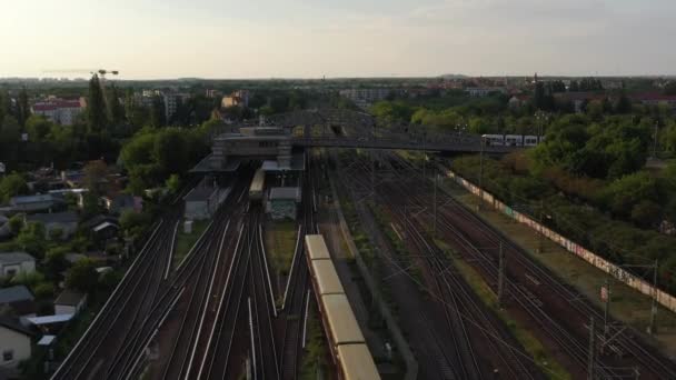 Do przodu śledzenie pociągu dojeżdżającego do stacji podczas przejazdu tramwajem przez tory kolejowe przez most Bosebrucke. Scena miejska w godzinach wieczornych. Berlin, Niemcy — Wideo stockowe