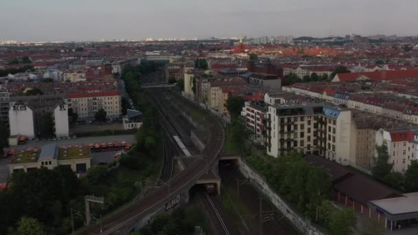 Aerial view of regional train driving on railway tracks between residential tenement houses in city. Berlin, Germany — Stock Video