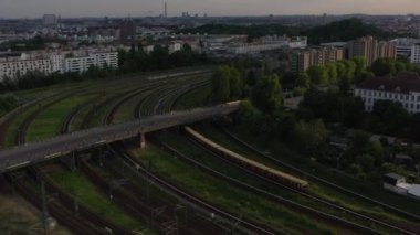 S bahn tren istasyonuna giden rayların izini sürüyorum. Şehir manzarası akşam güneşiyle aydınlanıyor. Berlin, Almanya