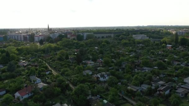 Fliegen Sie über den Block der Schrebergärten neben den Bahngleisen. Entlarvung der urbanen Nachbarschaft. Blick gegen die Nachmittagssonne. Berlin, Deutschland — Stockvideo