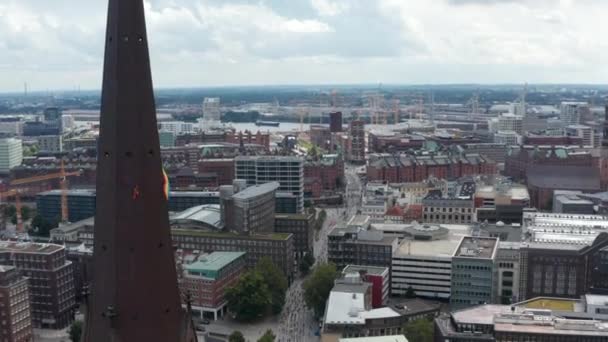 Stigande bilder längs kyrktornet avslöjar bryggor och röda tegelbyggnader i stadsdelen Speicherstadt. Fria och hanseatiska staden Hamburg, Tyskland — Stockvideo