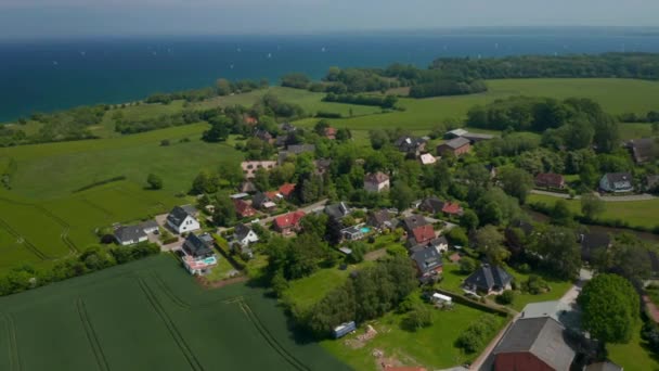 Drone aérien tournant autour de banlieues maisons quartier résidentiel à Brodten, Allemagne, fond mer Baltique, jour — Video