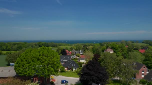 Vue aérienne survolant la banlieue résidentielle de Brodten, en Allemagne, les levers de drones révèlent un paysage incroyable de la mer Baltique, une journée ensoleillée — Video