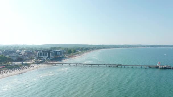 Vista aérea do drone que voa acima da praia do cais do mar Báltico em Scharbeutz, Alemanha, verão dia ensolarado, panela do círculo — Vídeo de Stock