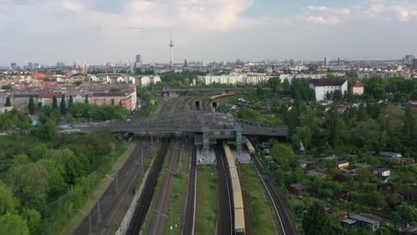 En avant voler au-dessus de la ligne de chemin de fer à voies multiples avec gare. Suivi du train S bahn arrivant en gare sous le pont de Bosebrucke. Berlin, Allemagne — Video