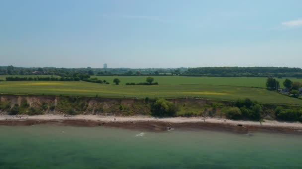 Балтійський морський повітряний безпілотник дивиться на величезне весняне зелене поле і узбережжя Балтійського моря в Бродтені, Німеччина, дольє за день. — стокове відео
