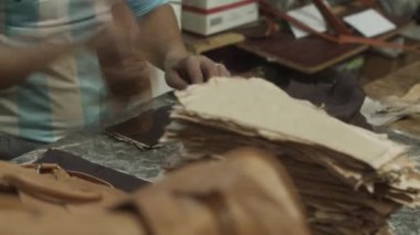 Deri fabrikasında çalışan bir adam. Taş tabakta tahta aletlerle deri parçalarını çekiçlemek. Eski fabrikada geleneksel el yapımı bir işlem. Fas, Afrika