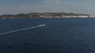 İspanya 'nın sakin ve sessiz denizi İbiza' da, bulutlu bir akşamda, su sporlarında eğlenen tanınmamış bir adamın hava manzarası.