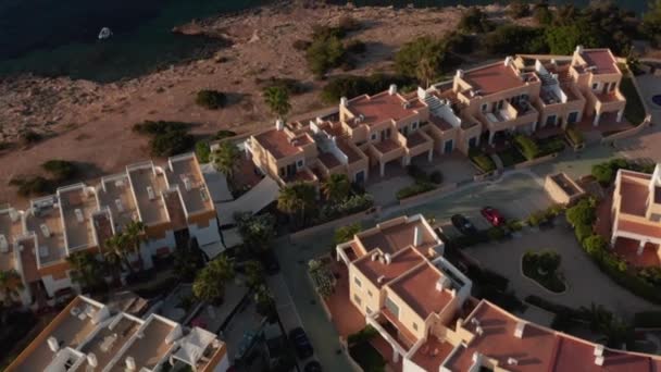 海岸と海岸の近くに植民地時代の美しい家の屋上の空中ビュー早朝の間にスペインのイビサ島の海と山に囲まれて — ストック動画