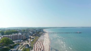 Güneşli bir günde sahil turizmi kıyı şeridinin havadan görüntüsü, Baltık denizi, Scharbeutz, Almanya, dolly in