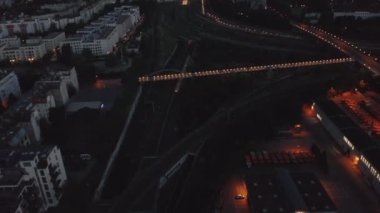 Sabahın erken saatlerinde aydınlık tren istasyonuna giden trenin hava görüntüsü. Gün doğmadan önce şehir. Berlin, Almanya