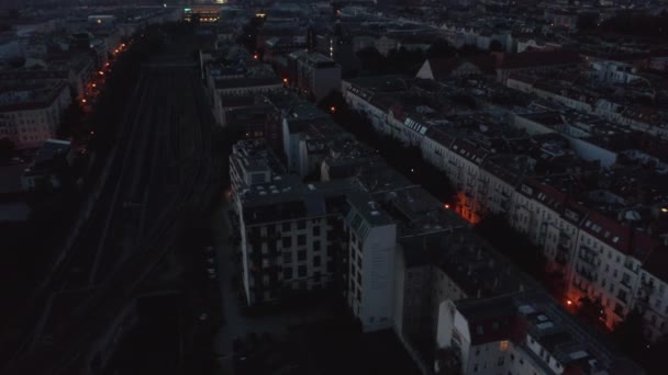 Vuela por encima de bloques de edificios residenciales. Inclinado hacia arriba revelan vista de la ciudad antes del amanecer. Cielo crepuscular colorido. Berlín, Alemania — Vídeo de stock