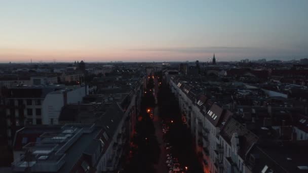 前方市内の広範かつ直線通りの上を飛ぶ。カラフルな夕暮れの空に対して表示します。ドイツ・ベルリン — ストック動画