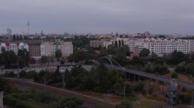 Şehirdeki tren yolu ve yol köprüsünün üzerinden uç. Fernsehturm TV kulesi uzakta. Berlin, Almanya