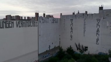 İleriye dönük şehirli mahalleleri gösteriyor. Yükselen güneşe karşı büyük kasabadaki yerleşim yerlerinin yukarısında alçak uçuş. Berlin, Almanya