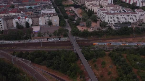 Zpětně přeletět železniční uzel. Nakloňte se odhalit městské čtvrti ve velkém městě. Berlín, Německo — Stock video