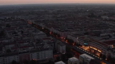 Morning City 'nin görüntülerini oynat ve yatır. Geniş cadde, güneş doğmadan önce çok katlı evler, turuncu alacakaranlık gökyüzü. Berlin, Almanya