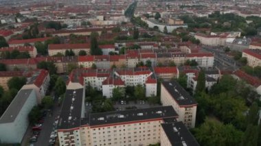 Şehir çevresindeki binaların üzerinden ileriye doğru uçuyor. Uzun düz bir caddesi ve Fernsehturm TV kulesi olan büyük bir şehir. Berlin, Almanya
