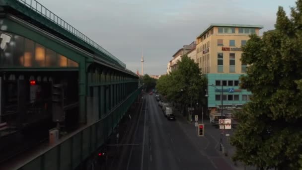 Adelante vuelan alrededor de la estación elevada Ubahn en la calle Schoenhauser Allee. Imágenes ascendentes revelan paisaje urbano con la torre de televisión Fernsehturm. Berlín, Alemania — Vídeo de stock