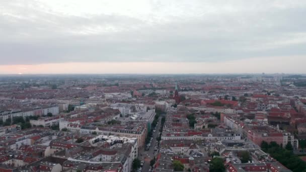 A frente voa acima da cidade grande na hora do nascer do sol. Incline as imagens de edifícios e ruas no bairro urbano. Berlim, Alemanha — Vídeo de Stock