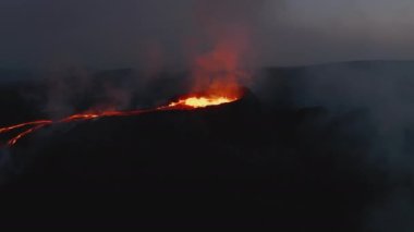 Geceleri volkan patlamasının panoramik görüntüsü. Kraterde magma ve erimiş lav akışı. Fagradalsfall volkanı. İzlanda, 2021