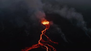 Aktif volkanın gece hava görüntüsü. Kaynayan magma, dallanmış lav akıntılarıyla kraterden akıyor. Fagradalsfall volkanı. İzlanda, 2021
