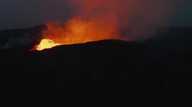 Aktif volkan kraterinin yörüngesinde. Sıcak kaynar magma. Giden volkanik gazlar ışık parıltısını yansıtıyor. Fagradalsfall volkanı. İzlanda, 2021