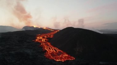 Aktif volkan dağındaki erimiş lav akıntılarının kayması. Şafakta sıcak magma patlaması. Fagradalsfall volkanı. İzlanda, 2021