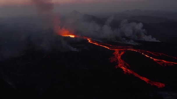 Inclina imágenes del volcán activo contra el cielo rosado del amanecer. Flujos de lava fundida caliente en la ladera de la montaña. Volcán Fagradalsfjall. Islandia, 2021 — Vídeos de Stock