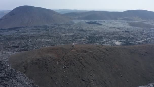 Orbit shot around helicopter landed on elevated ground surrounded by new lava filed. Panoramic view of volcanic landscape. Fagradalsfjall volcano. Iceland, 2021 — Stock Video