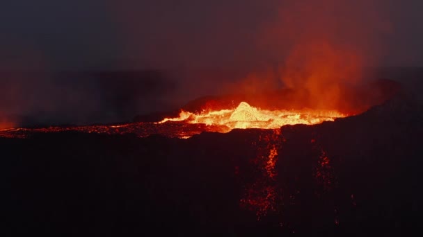 Vista de cerca de la parte superior del volcán activo. Material magmático hirviendo salpicando del cráter. lava fundida que fluye por el arroyo. Volcán Fagradalsfjall. Islandia, 2021 — Vídeos de Stock